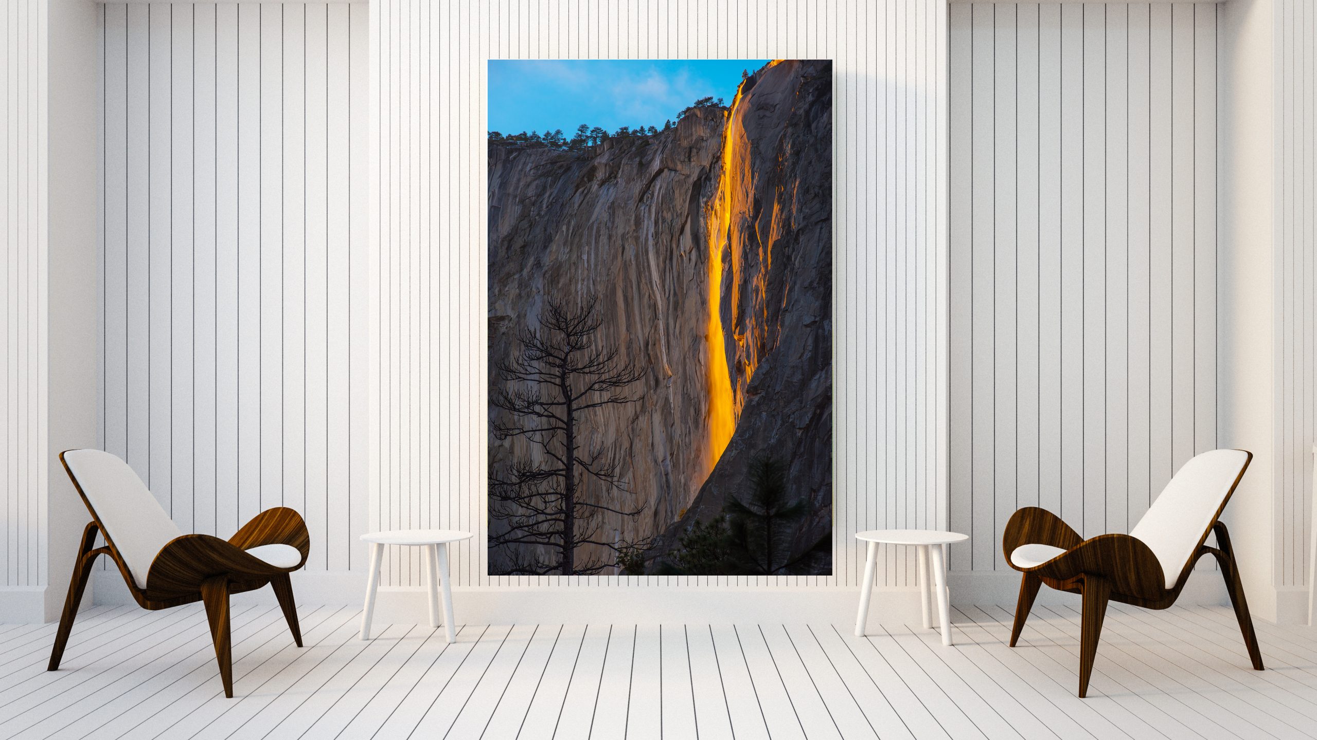 Large photo wall art of Horsetail Falll, Yosemite,in a modern white room with two chairs.